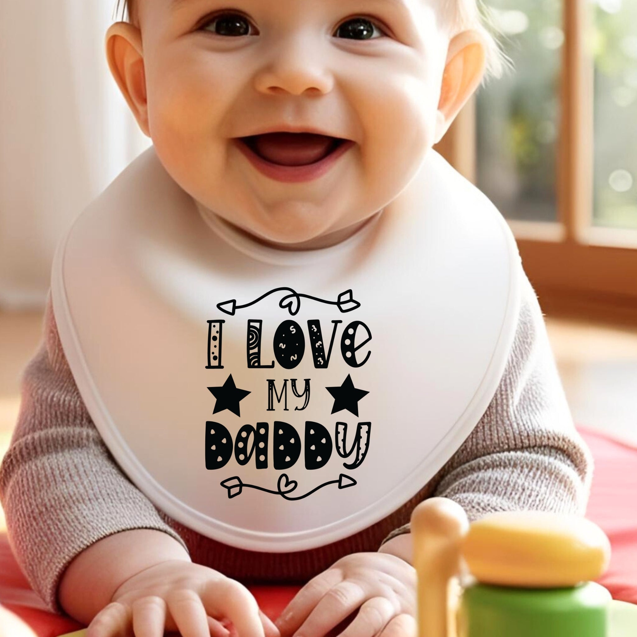 Baby wearing a bib with 'I Love My Daddy' text, sitting indoors. Gifts for dad. Stocking Filler