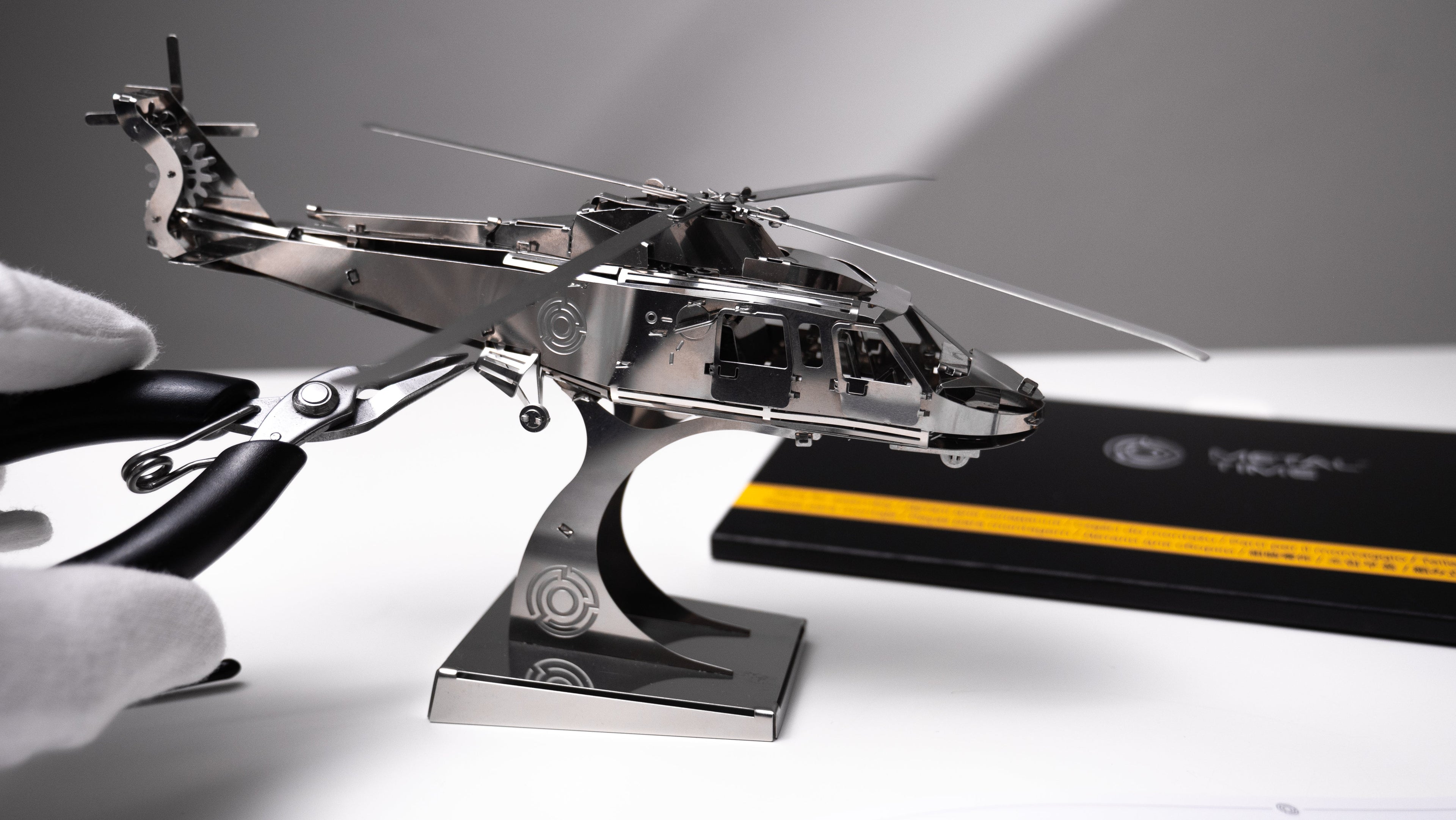 Metallic model of a helicopter on a stand with a gray background - Gifts for  dad